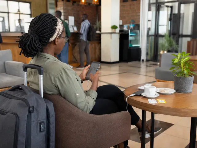 Traveller using a mobile phone while staying connected in Uganda